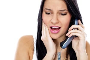 woman jaw pain calling dentist