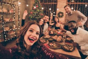 Diverse group of people smiling and sharing a holiday meal